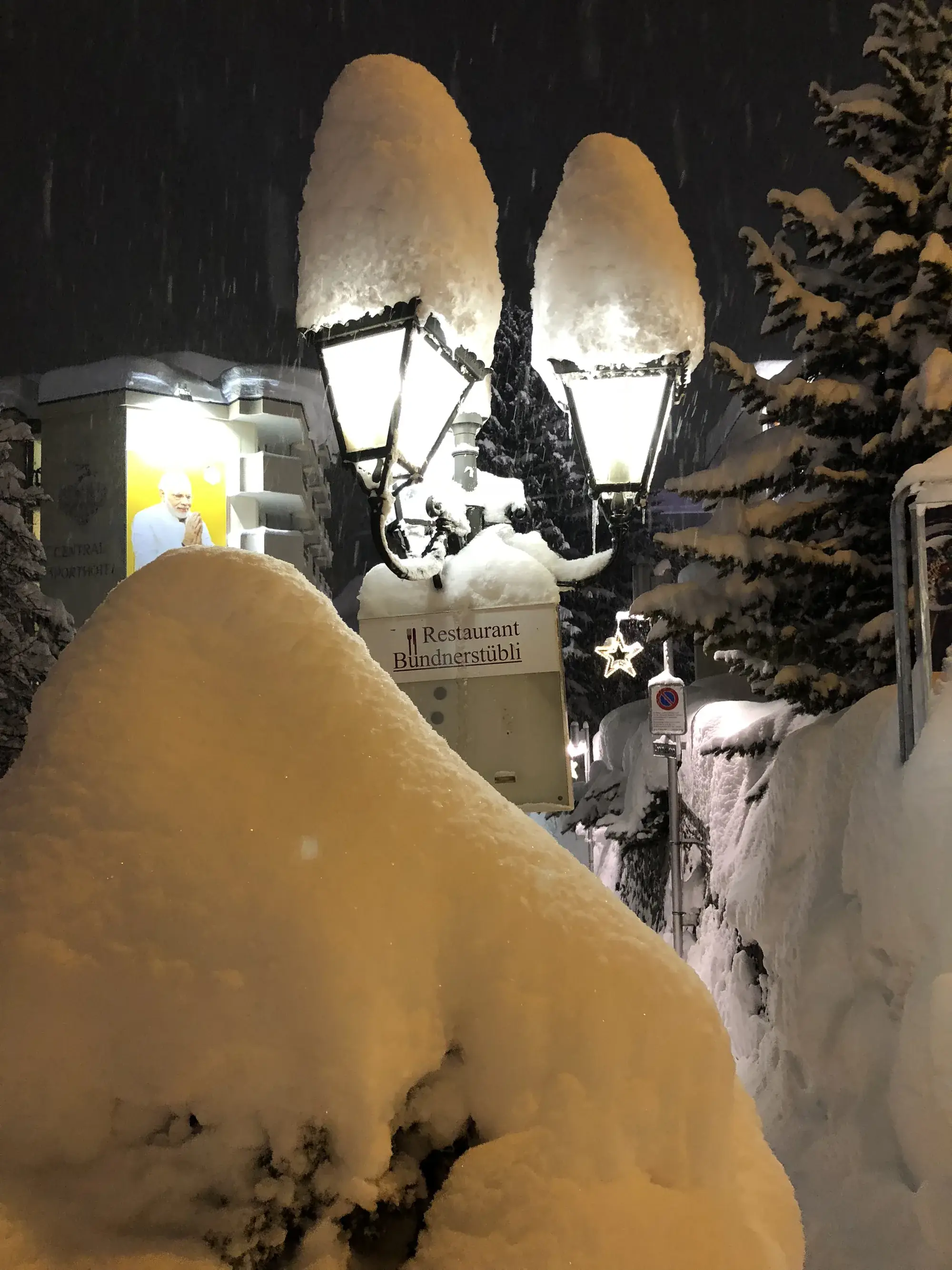 Snow-capped lanterns outside a Davos restaurant on a snowy evening